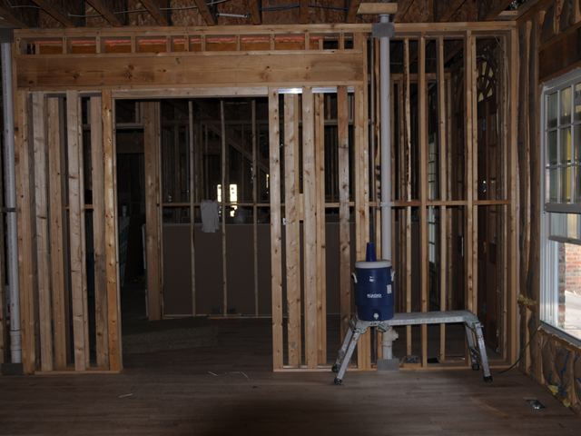 Wiring and plumbing running through open stud walls